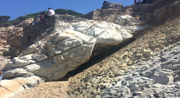 La couche géologique la plus. sombre visible sur cette photo - riche en iridium - est la célèbre couche KT (Crétacé - Tertiaire). Epaisse de seulement quelques centimètres, elle marque la transition entre l'apparition des dinosaures et leur extinction. On peut l'observer partout sur la planète, notamment sur la place de Bidart, en France. (Photo prise par l'auteur).